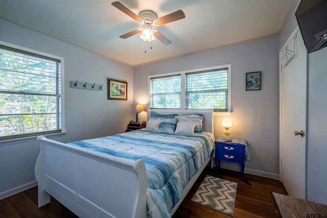 bedroom featuring dark hardwood / wood-style flooring, ceiling fan, and ornamental molding