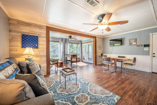 living room with french doors, crown molding, ceiling fan, and dark wood-type flooring