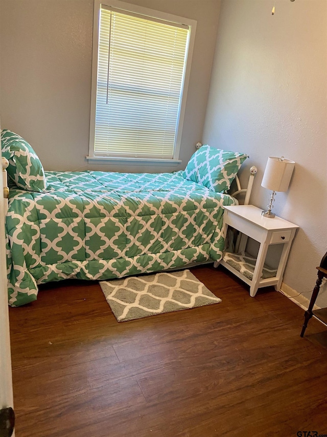 bedroom with dark hardwood / wood-style flooring