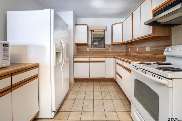 2759 Lake Breeze Dr, Chandler, TX 75758 - kitchen with white appliances, under cabinet range hood, light countertops, white cabinets, and backsplash