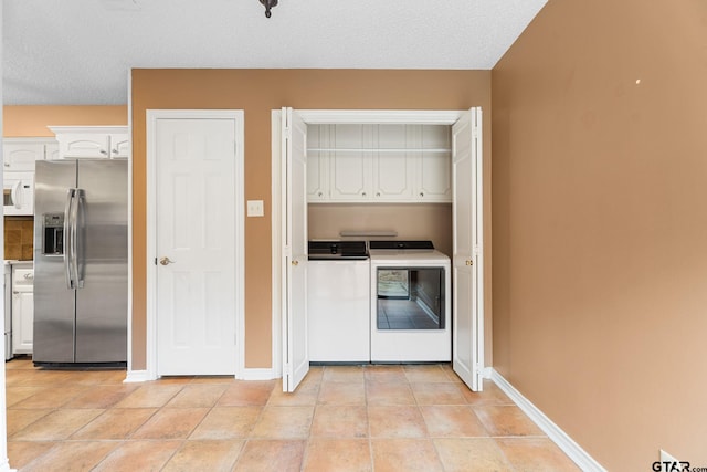 507 Hyde Park, Tyler, TX 75701 - kitchen featuring stainless steel fridge, separate washer and dryer, white cabinetry, white microwave, and light tile patterned flooring