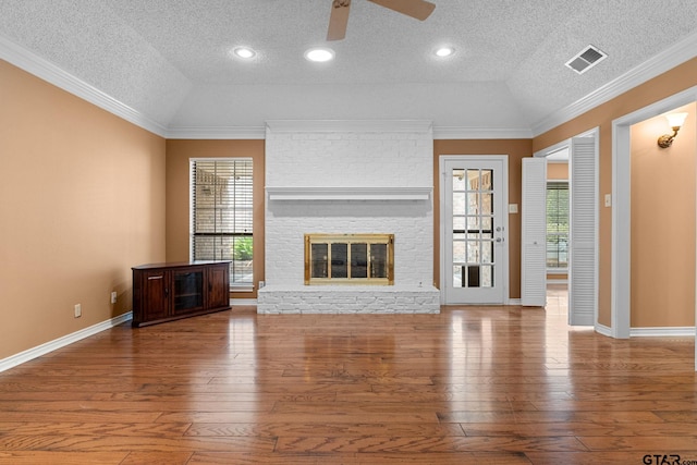507 Hyde Park, Tyler, TX 75701 - unfurnished living room featuring a textured ceiling, a ceiling fan, hardwood / wood-style floors, a fireplace, and crown molding