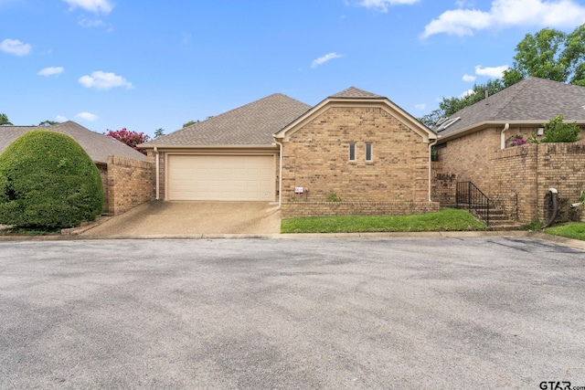 507 Hyde Park, Tyler, TX 75701 - view of front of home featuring brick siding, an attached garage, driveway, and a shingled roof