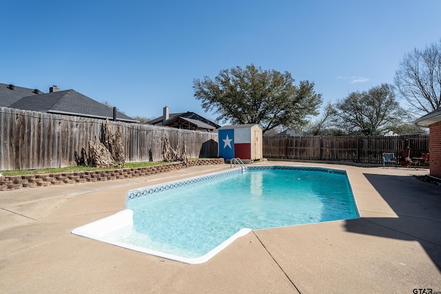 view of swimming pool with a fenced in pool, a shed, an outdoor structure, a fenced backyard, and a patio area