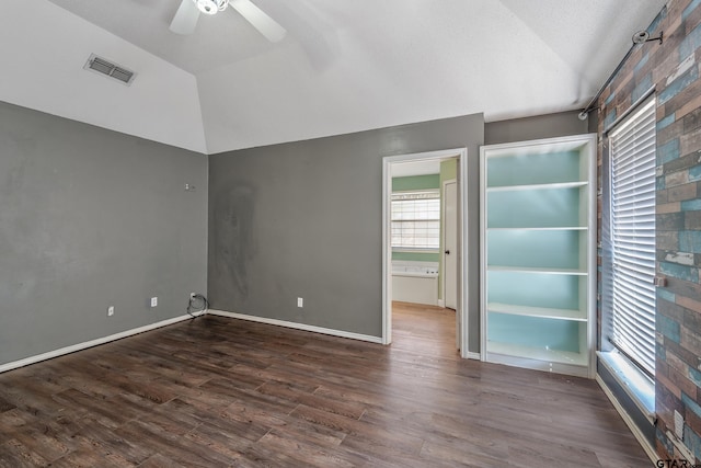 spare room with visible vents, baseboards, lofted ceiling, wood finished floors, and a ceiling fan