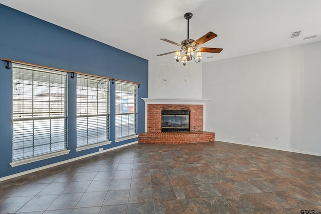 unfurnished living room featuring visible vents, a fireplace, baseboards, and ceiling fan