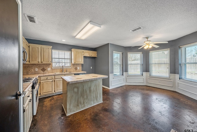 kitchen featuring a ceiling fan, visible vents, stainless steel appliances, light brown cabinetry, and tile counters