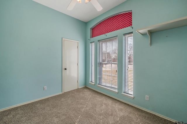 carpeted empty room with a wealth of natural light and ceiling fan