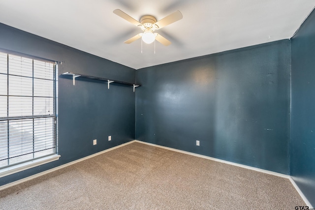 carpeted spare room with baseboards and ceiling fan