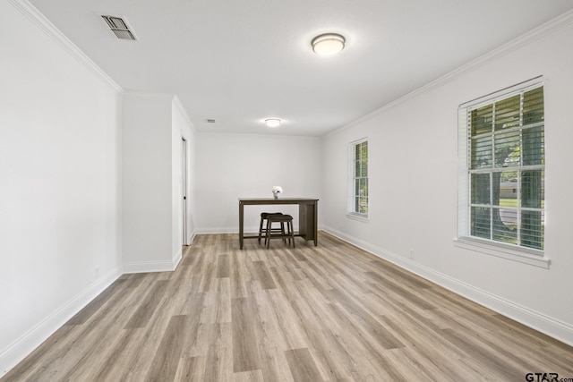 interior space featuring crown molding, light wood finished floors, baseboards, and visible vents