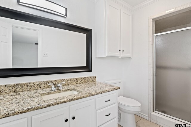 bathroom featuring ornamental molding, toilet, a stall shower, and vanity