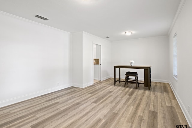 interior space with crown molding, visible vents, baseboards, and light wood-type flooring