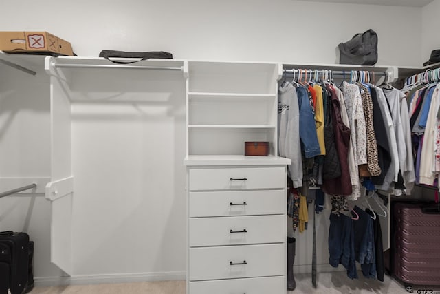 walk in closet featuring light colored carpet