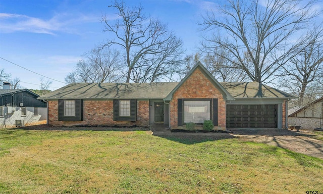 view of front of house featuring driveway, brick siding, an attached garage, and a front yard