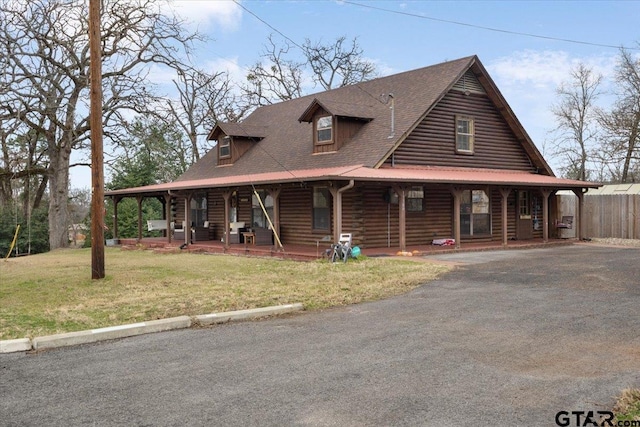 log cabin featuring covered porch and a front yard