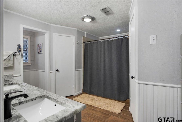 bathroom with crown molding, vanity, and a textured ceiling