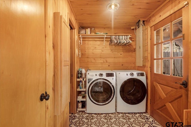 washroom featuring light tile patterned flooring, wooden ceiling, washer and clothes dryer, and wood walls