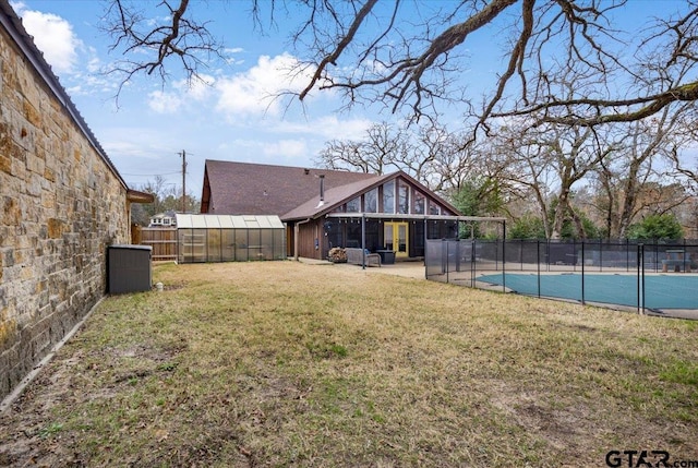 rear view of property with a yard, an outdoor structure, and a covered pool