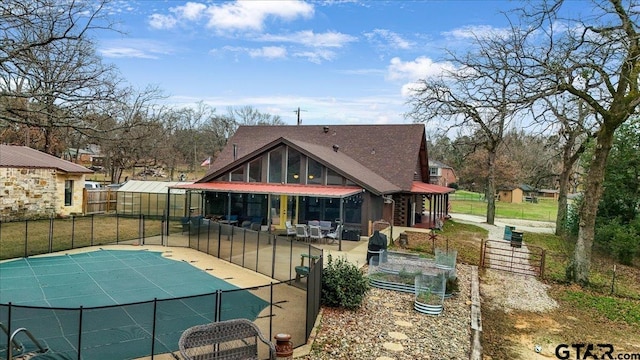 back of house featuring an outdoor living space, an outdoor structure, a covered pool, and a patio area