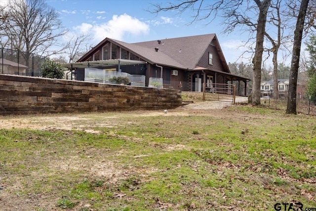 rear view of house featuring a yard