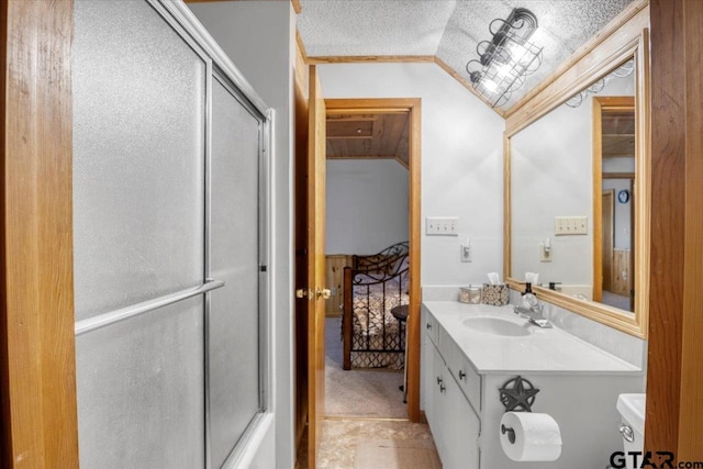 bathroom featuring lofted ceiling, vanity, a textured ceiling, toilet, and walk in shower