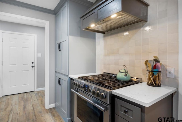 800 Neches Dr, Tyler, TX 75702 - kitchen with high end stove, premium range hood, tasteful backsplash, light wood-type flooring, and gray cabinets