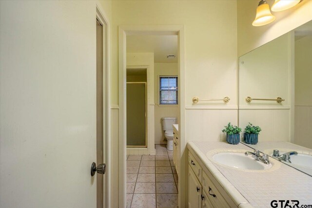 800 Neches Dr, Tyler, TX 75702 - full bathroom with vanity, a shower stall, and wainscoting