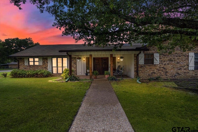 800 Neches Dr, Tyler, TX 75702 - view of front of home with a front lawn, covered porch, brick siding, and board and batten siding