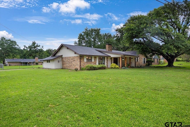 800 Neches Dr, Tyler, TX 75702 - ranch-style house with a chimney, a front lawn, and brick siding