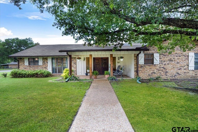 800 Neches Dr, Tyler, TX 75702 - view of front of home with a front lawn, a porch, brick siding, and board and batten siding