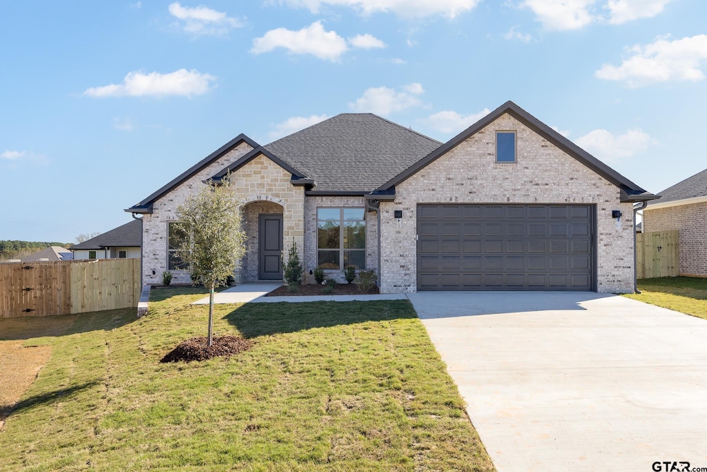 view of front of house featuring a garage and a front lawn