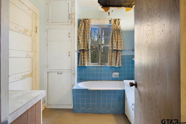 bathroom featuring vanity and tiled bath