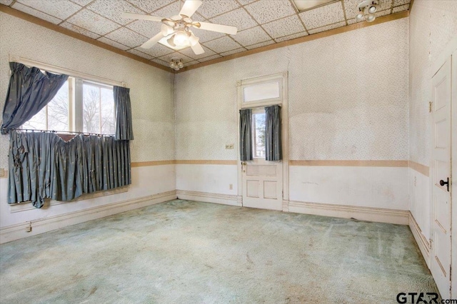 carpeted spare room featuring plenty of natural light, a paneled ceiling, and ceiling fan