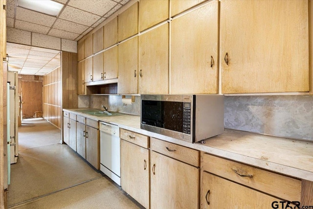 kitchen featuring sink, a paneled ceiling, fridge, white dishwasher, and light brown cabinetry