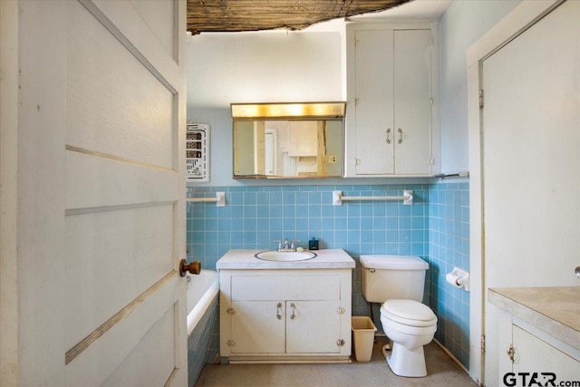 bathroom featuring vanity, toilet, a bathing tub, and tile walls