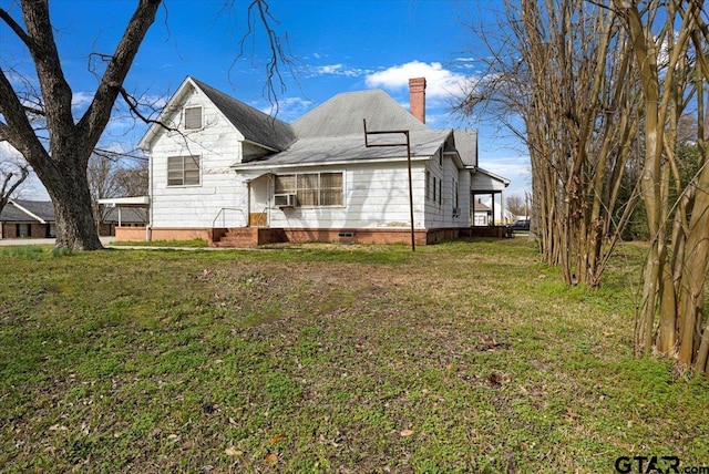 rear view of house featuring cooling unit and a lawn