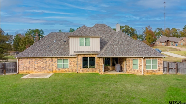 back of property with a lawn and a patio area