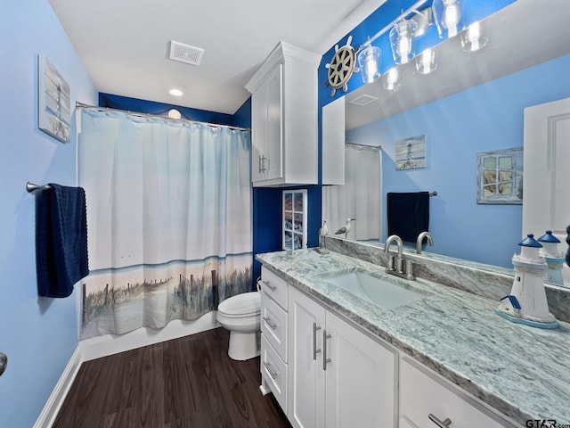 bathroom with baseboards, visible vents, toilet, wood finished floors, and vanity