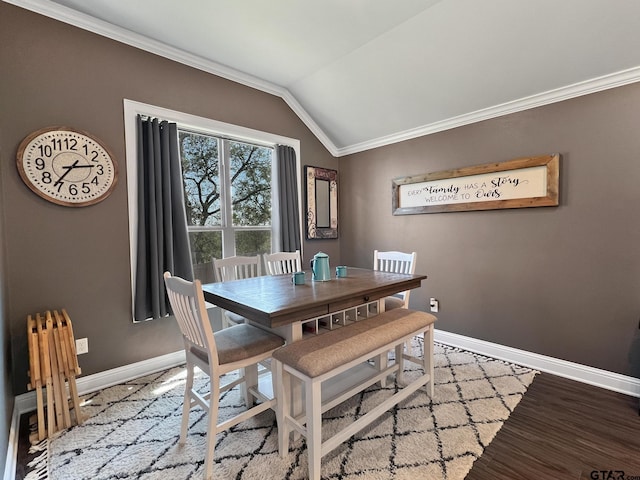 dining room with ornamental molding, lofted ceiling, and hardwood / wood-style floors