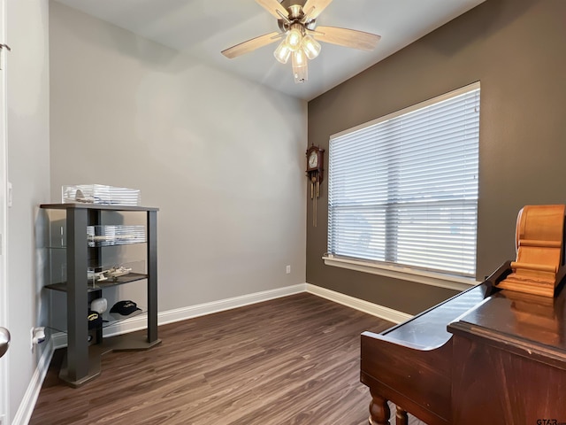 office space with a ceiling fan, dark wood-type flooring, and baseboards