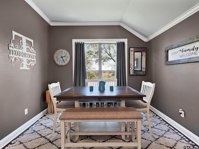 dining area featuring lofted ceiling, ornamental molding, and baseboards