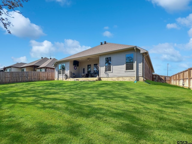 rear view of property with ceiling fan, a yard, a patio, and a fenced backyard