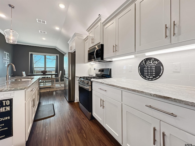 kitchen with stainless steel appliances, tasteful backsplash, a sink, and visible vents