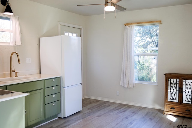 kitchen featuring white fridge, a healthy amount of sunlight, and light hardwood / wood-style flooring