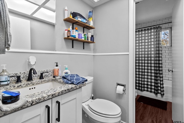 full bathroom with hardwood / wood-style floors, vanity, toilet, and shower / bath combination with curtain