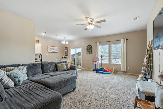 109 Summit Cv, Jacksonville, TX 75766 - carpeted living room with a chandelier, ceiling fan, baseboards, and a sink