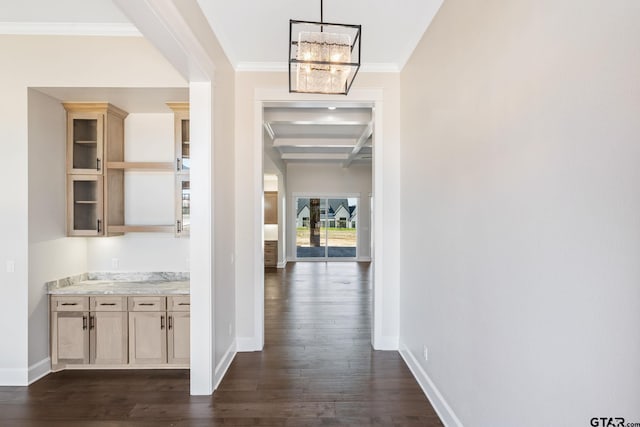 corridor with an inviting chandelier, dark hardwood / wood-style floors, and ornamental molding