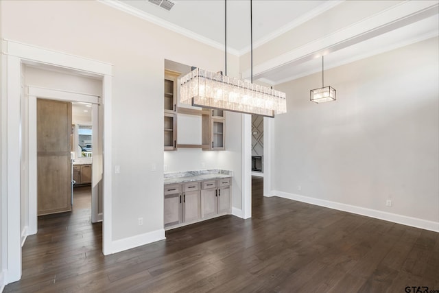 kitchen with dark wood-type flooring, hanging light fixtures, crown molding, and light stone counters