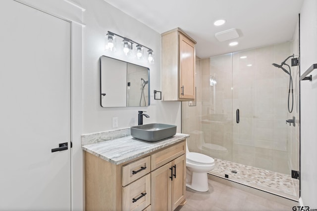 bathroom featuring vanity, tile patterned flooring, toilet, and a shower with shower door