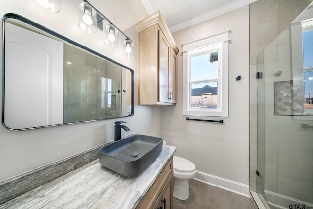 bathroom with toilet, vanity, ornamental molding, and walk in shower